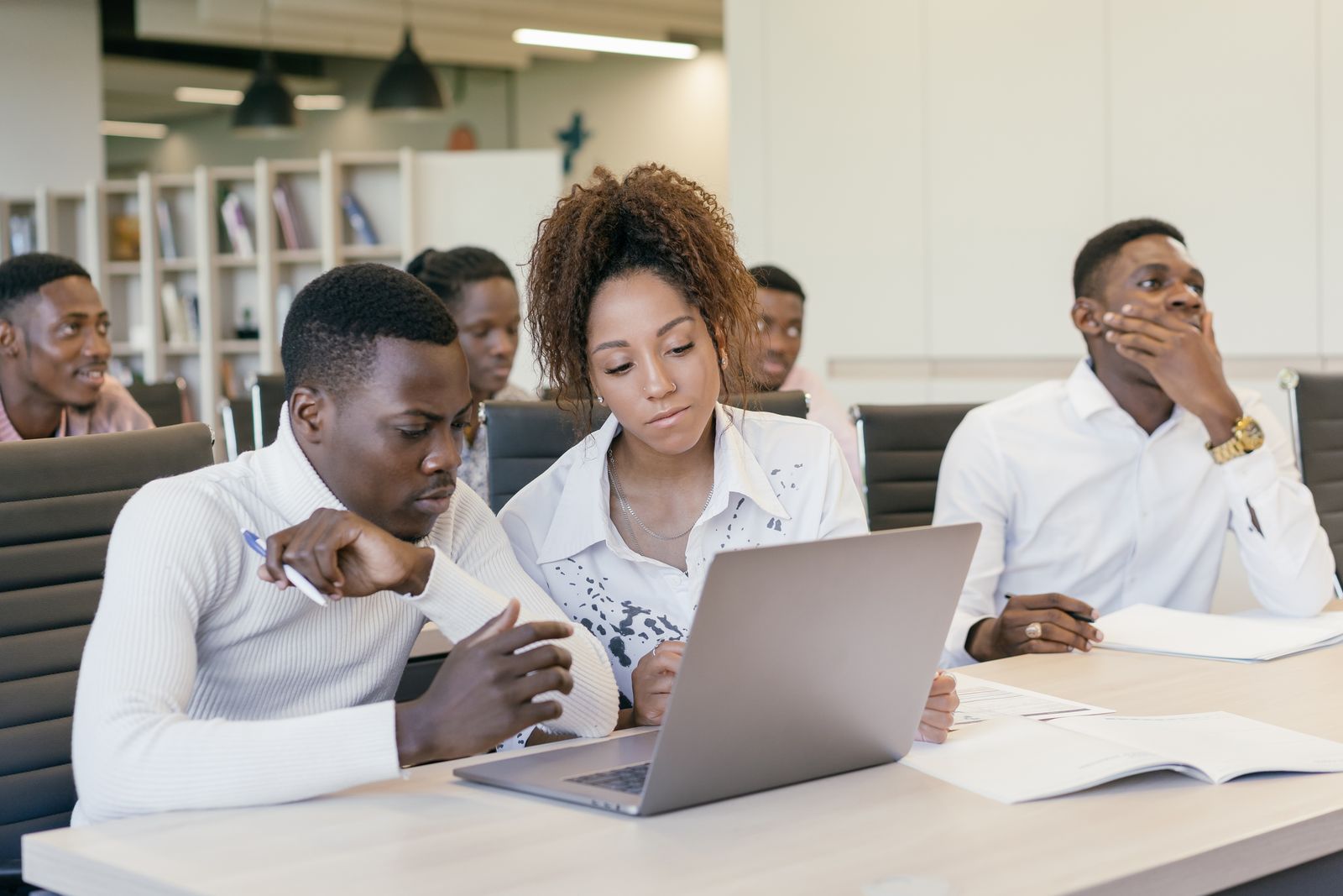 Colleagues planning together around laptops in a bright office