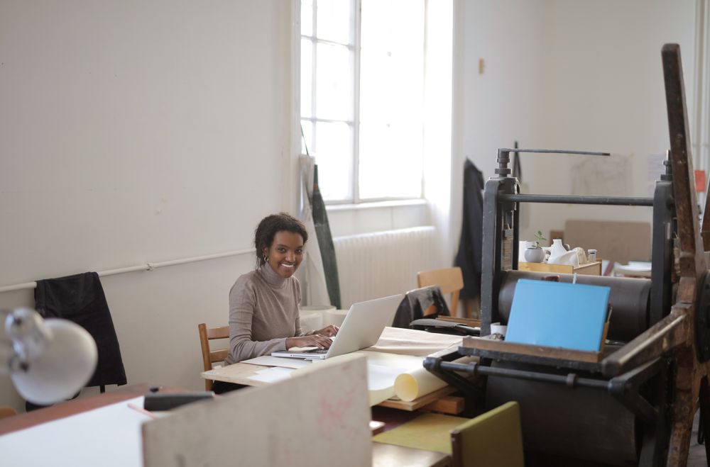 A customer success professional smiling while working on her laptop