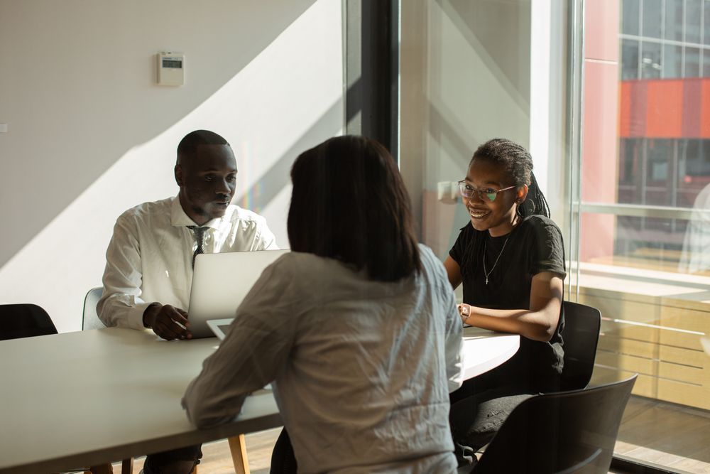 Three professionals in a planning meeting in a sunlit office