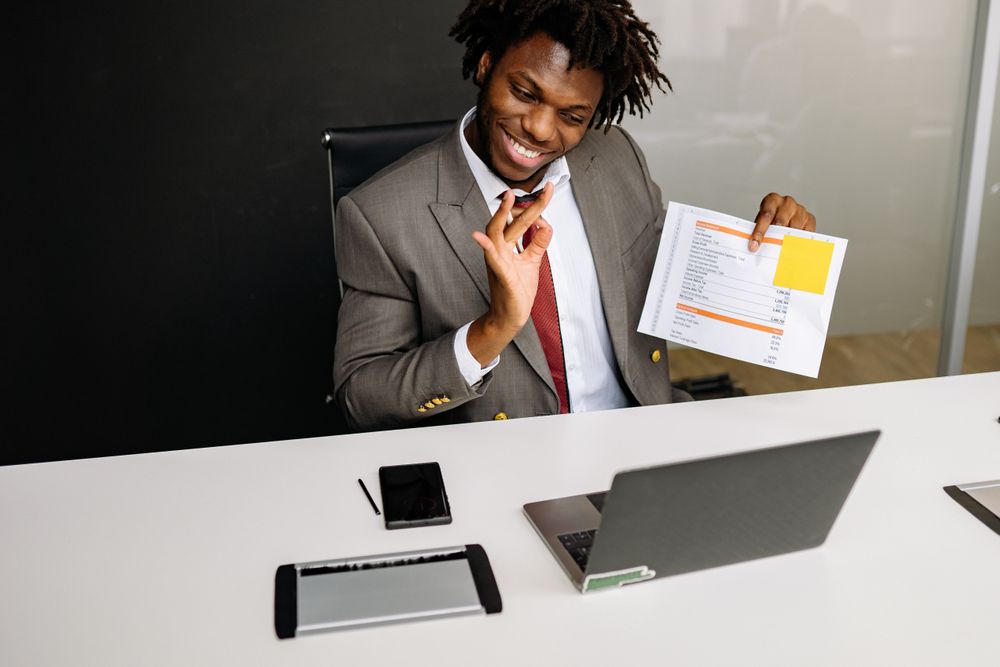 A sales professional on a video call holding documents